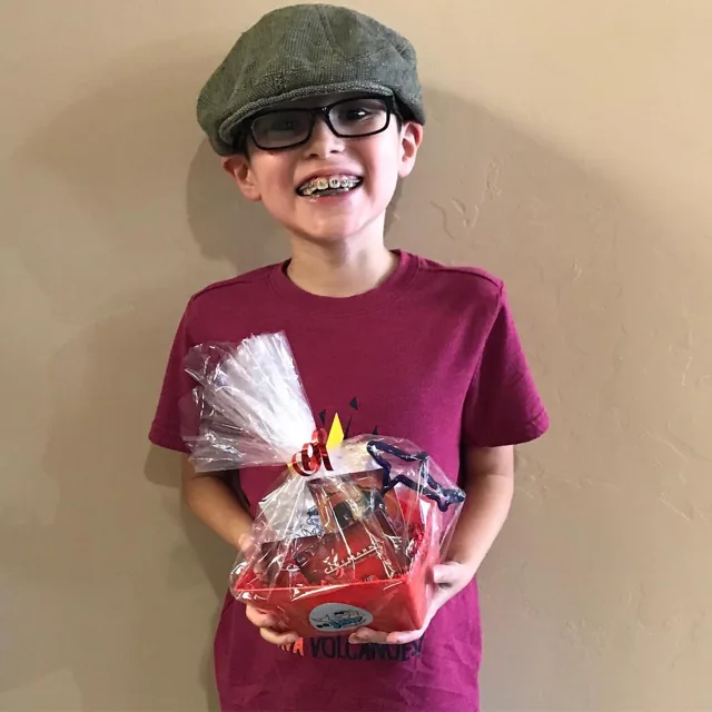 A smiling Dr. JAW patient holding a gift basket