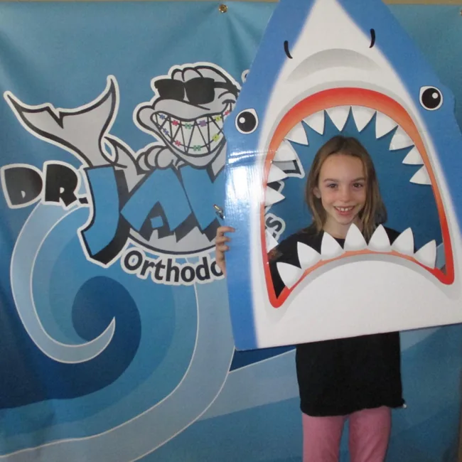 A patient posing in Dr. JAW’s shark photo booth